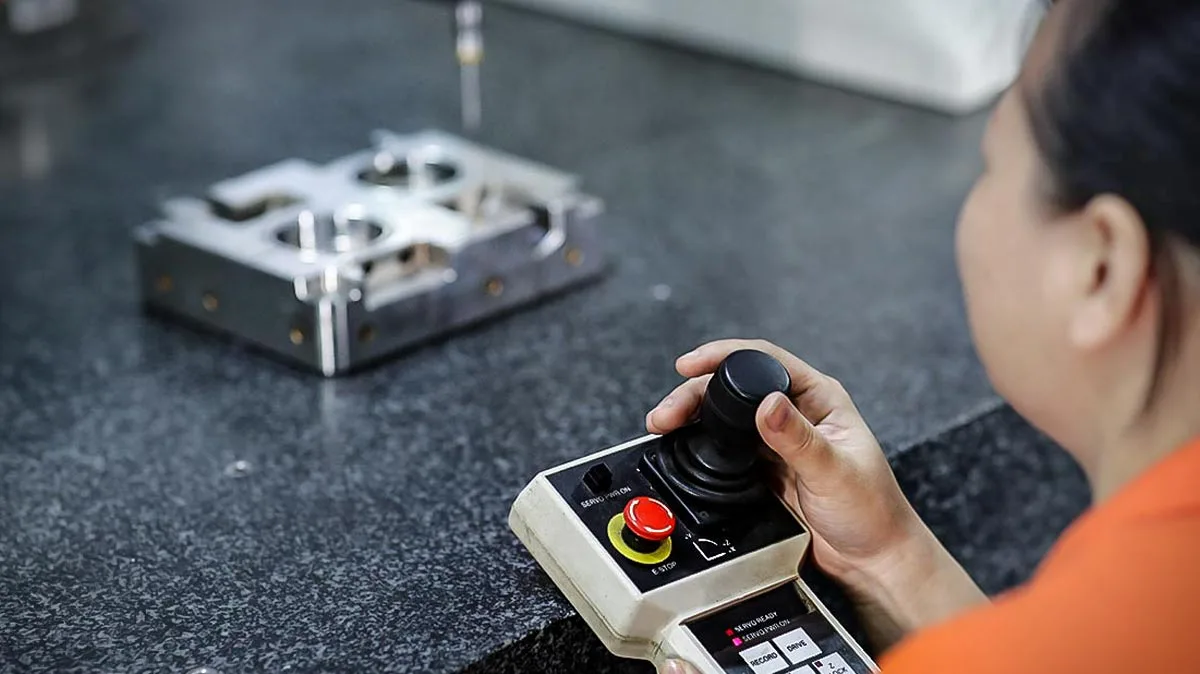 Operator measuring a machined mold component with a CMM