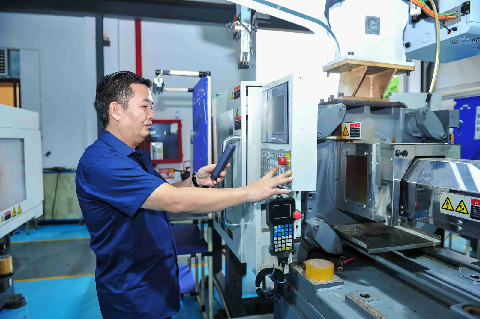 Technician adjusting injection molding equipment