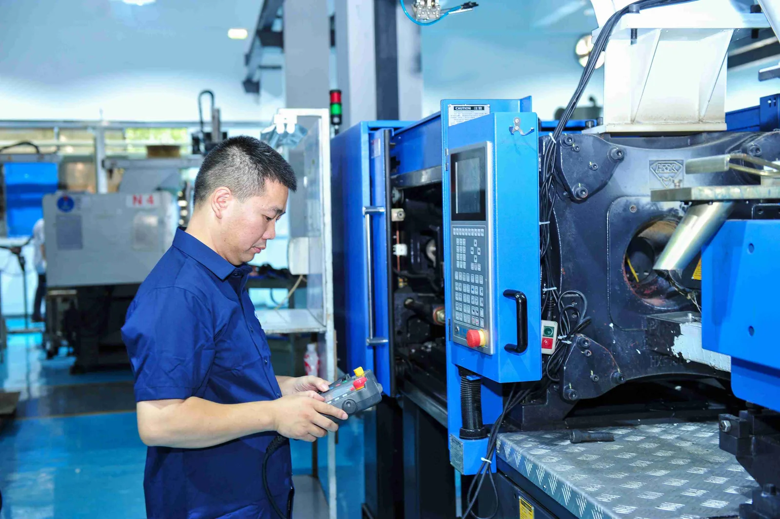 Technician operating an injection molding machine