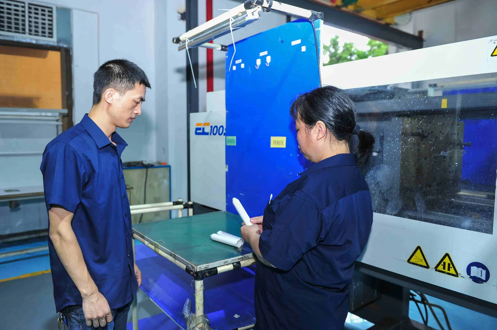 Technicians reviewing an injection molding process