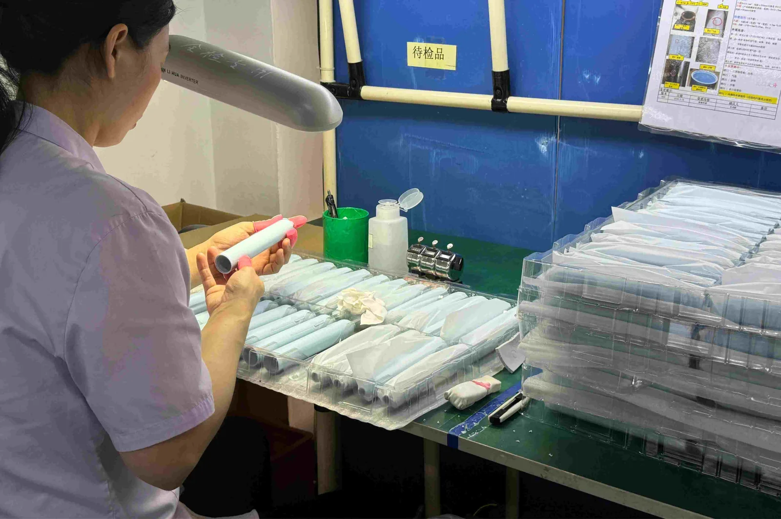 Worker checking molded plastic parts at a workbench